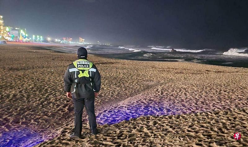 1月1日，日本发生大地震后，韩国海岸警卫队在江陵海滩观测海平面。（法新社）