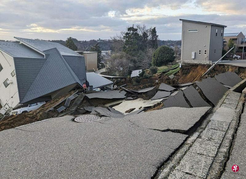 日本石川县能登半岛1月1日下午发生7.6级地震，图为石川县轮岛市的一条道路破裂，房屋倒下。（路透社）