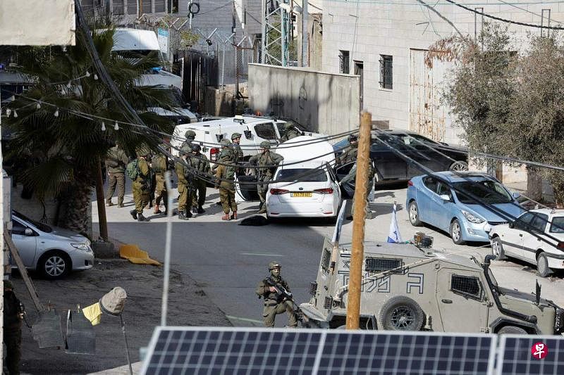 2月1日，在约旦河西岸希伯伦一枪击现场，多名以色列军人包围一辆汽车，气氛紧张。（路透社）