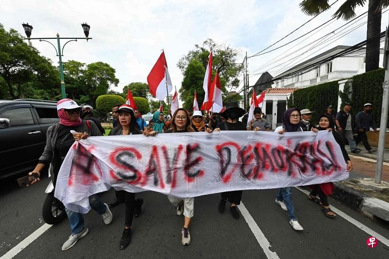 2月23日，印尼民众在雅加达游行示威，要求当局调查选举期间的违规行为。抗议者手举“拯救民主”口号横幅，向印尼国家选举委员会办公室前进。（法新社）