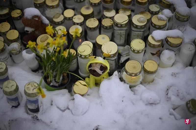 芬兰校园枪击案酿一死二伤，全国星期三下半旗志哀，不少民众也到校园外放上蜡烛和鲜花悼念死者。（法新社）