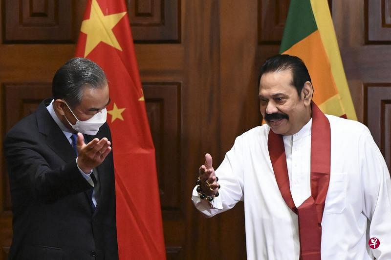 斯里兰卡总统拉贾帕克萨（右）周日（9日）在科伦坡与中国外交部长王毅（左）会晤时提出了债务重组的请求。（法新社）