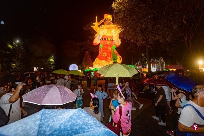 超过1200人齐聚滨海湾花园的海湾舫，与象征财源滚滚的巨型财神爷，以及五彩缤纷的灯饰合影。（关俊威摄）